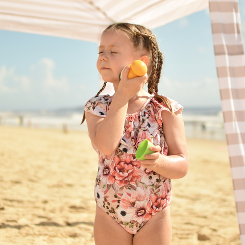 Image of young girl on beach applying sunscreen using Solar Buddies roll on applicator