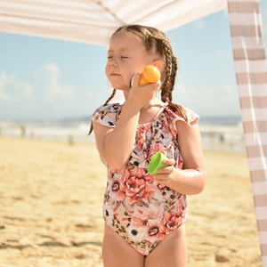 young girl on beach applying sunscreen using Solar Buddies roll on applicator