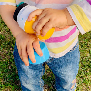 Young child applies sunscreen to arm with Solar Buddies roll on applicator